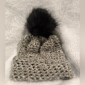 Grey & silver crocheted hat with black faux fur ball